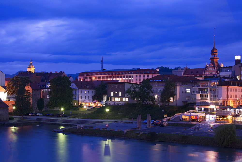 A cityscape of Maribor along the Draca River at night, Slovenia, Europe