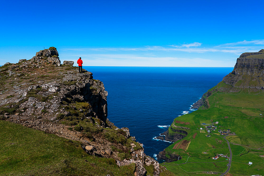 Hiker on The Postman's Trail to the village of Gasaldur, Vagar Island, Faroe Islands, Denmark, Europe