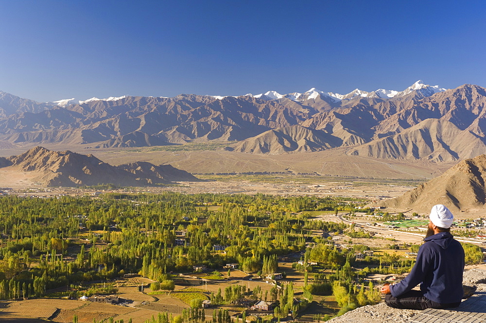 Man meditating, with view of Indus Valley and Stok-Kangri massif, Leh, Ladakh, Indian Himalayas, India, Asia