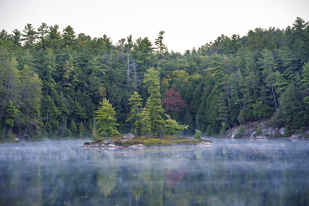 Mist rising on Bunnyrabbit Lake at dawn on La Cloche Silhouette Trail, Killarney Provincial Park, Ontario, Canada, North America