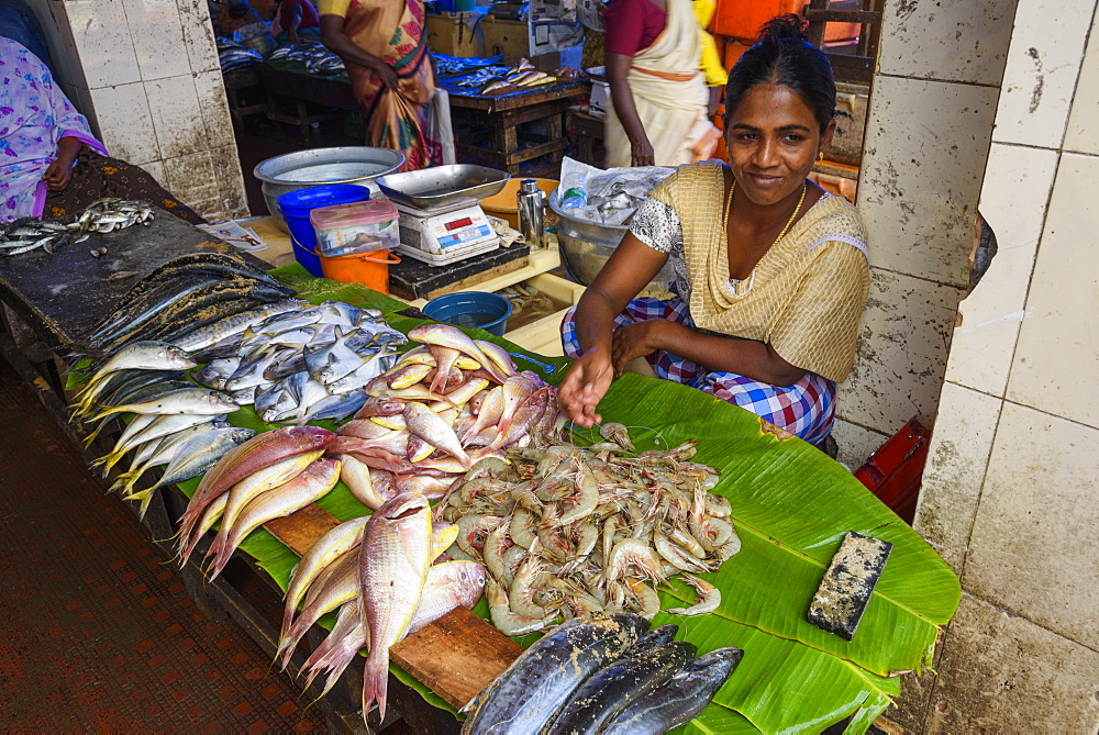 Woman selling fresh seafood at street market in Trivandrum, India