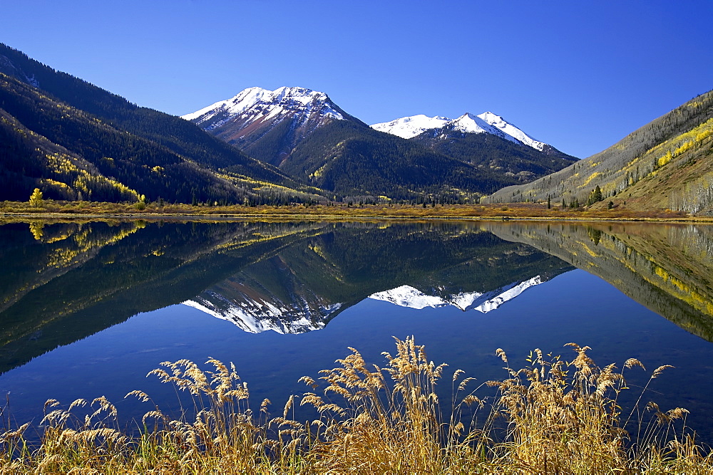 Snow-capped Red Mountain reflected in Crystal Lake with fall colors, near Ouray, Colorado, United States of America, North America