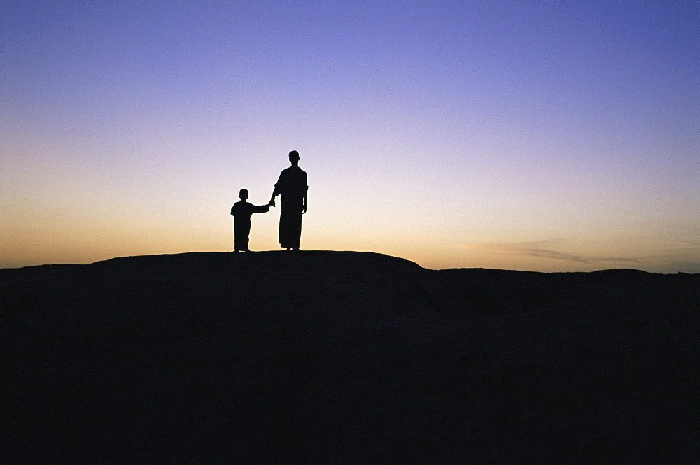 Silhouette of two people at the archaeological area, Kish, Iraq, Middle East