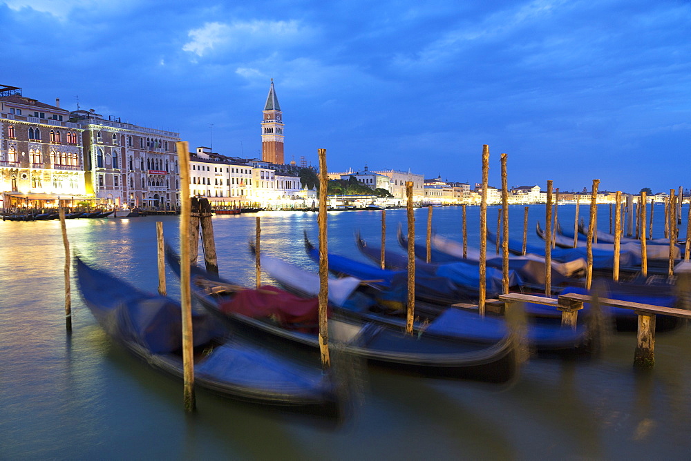 Gondolas moored at night at Campo della Salute on the Grand Canal with St. Mark's Campanile in the distance, Venice, UNESCO World Heritage Site, Veneto, Italy, Europe