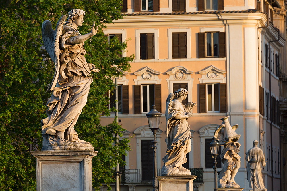 Angel statues on Ponte Sant' Angelo with grand house behind, Rome, Lazio, Italy, Europe