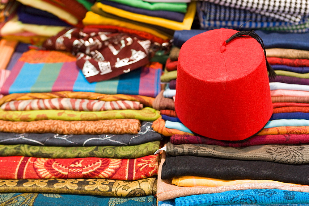 Colourful cotton fabric and a traditional fez for sale in a shop in Luxor, Egypt, North Africa, Africa