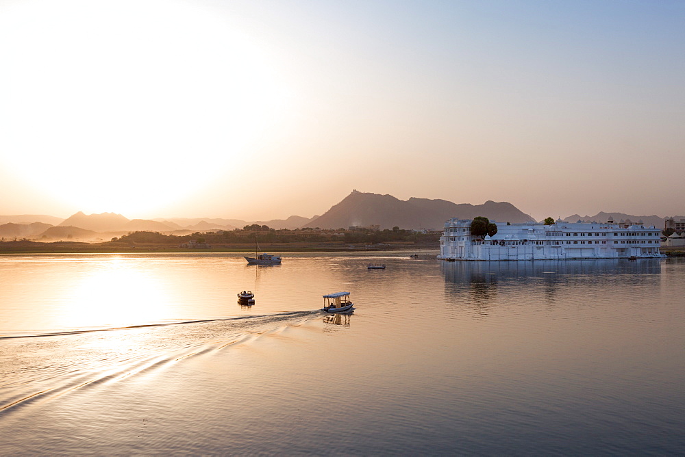 Boat going out to Lake Palace Hotel at dusk, the hotel is situated in the middle of Lake Pichola, in Udaipur, Rajasthan, India, Asia