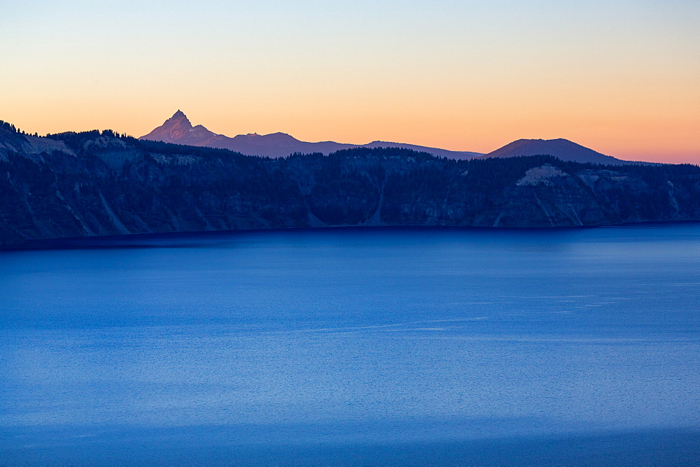 Dusk over the still waters of Crater Lake, the deepest lake in the U.S.A., with Mount Thielsen, part of the Cascade Range, Oregon, United States of America, North America