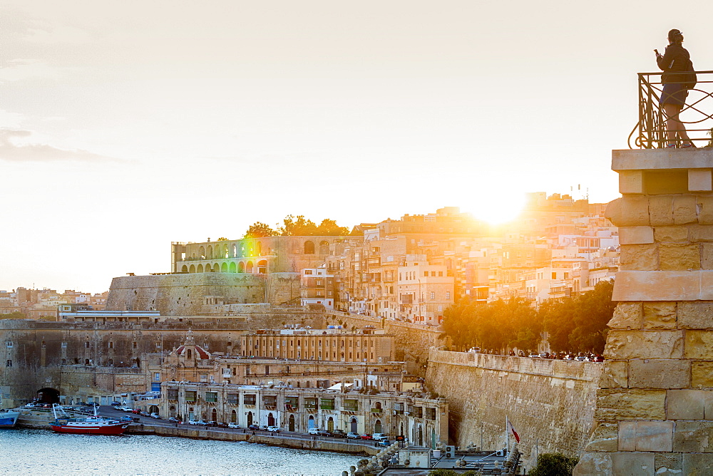 Person photographing the Grand Harbour in Valletta at dusk. Valletta, Malta, Mediterranean, Europe