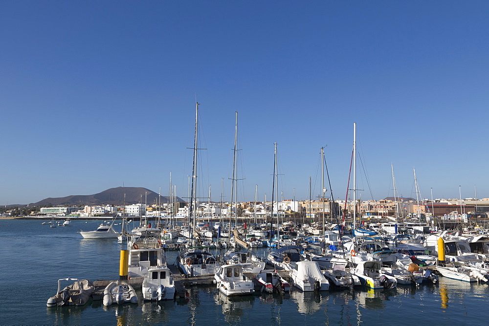 The harbour at Corralejo on the island of Fuerteventura with a volcano in the distance, Fuerteventura, Canary Islands, Spain, Atlantic, Europe