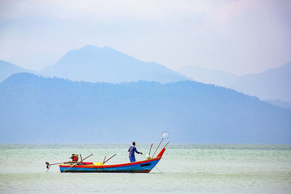 Fisherman on small boat, Strait of Malacca with Thai island of Ko Tarutao from Datai Bay Beach (Pantai Teluk Datai), Andaman Sea, Malaysia, Southeast Asia, Asia