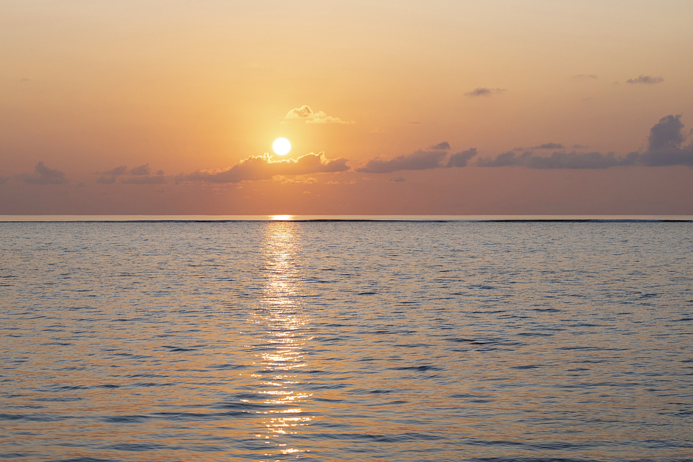 Sunset over the clear waters of the lagoon on an exotic Island in the Maldives. Indian Ocean.