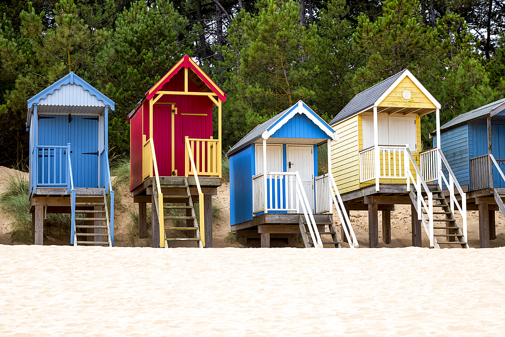 A row of colourful beach huts on the sand at Wells next the Sea in North Norfolk, United Kingdom
