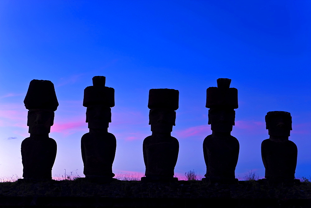 Anakena beach, monolithic giant stone Moai statues of Ahu Nau Nau, four of which have topknots, silhouetted at dusk, Rapa Nui (Easter Island), UNESCO World Heritage Site, Chile, South America