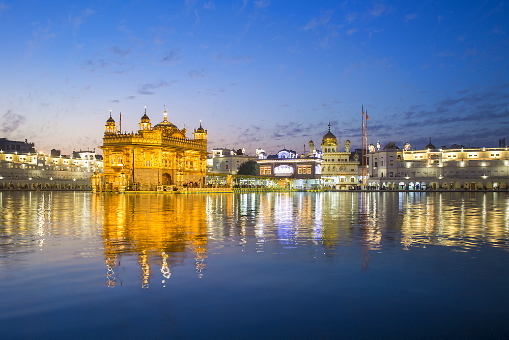 The Golden Temple (Harmandir Sahib) and Amrit Sarovar (Pool of Nectar) (Lake of Nectar), illuminated at dusk, Amritsar, Punjab, India, Asia