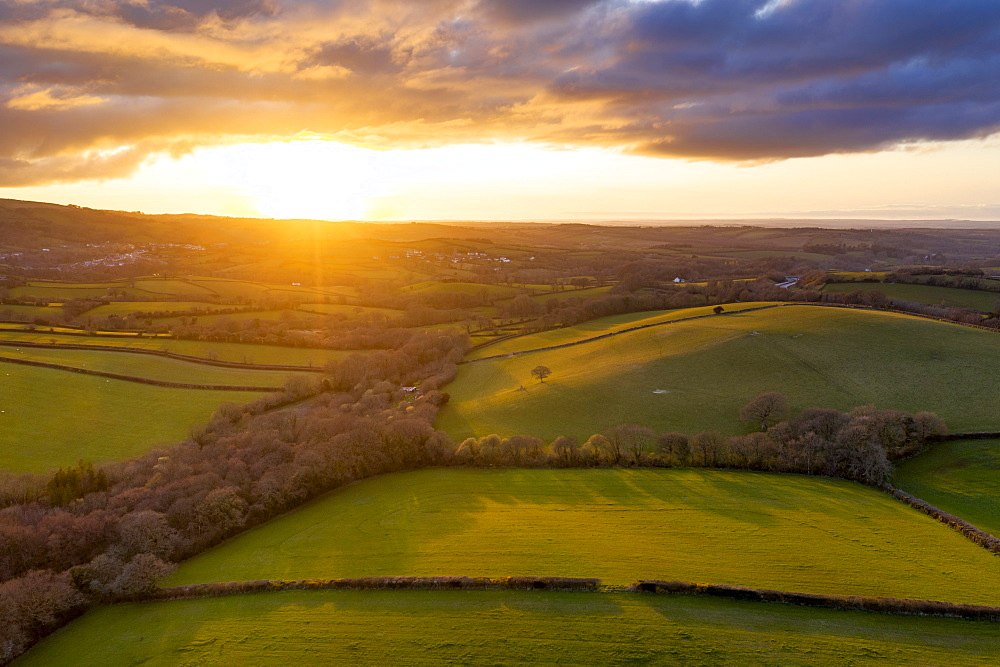 Aerial vista by drone of rolling countryside at sunset in spring, Devon, England, United Kingdom, Europe