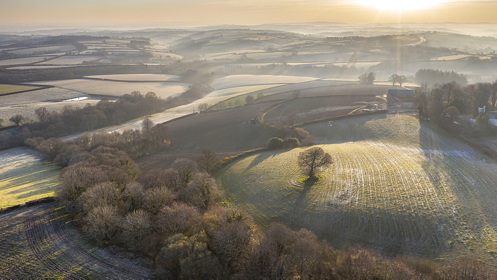 Aerial vista by drone of frosty rolling countryside at dawn in spring, Devon, England, United Kingdom, Europe