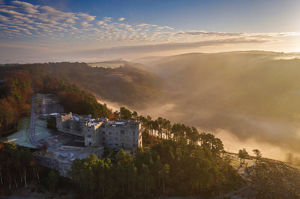 Aerial vista of Castle Drogo and the Teign Valley in morning mist in winter, Dartmoor, Devon, England, United Kingdom, Europe