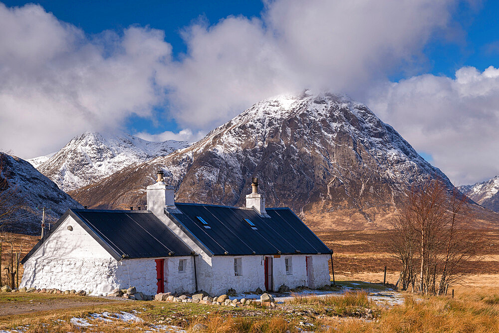 Black Rock Cottage bothy on Rannoch Moor with a snow dusted Buachaille Etive Mor looming behind in winter, Highlands, Scotland, United Kingdom, Europe