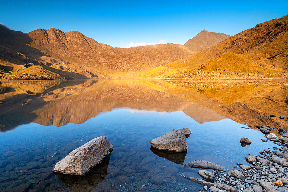 Early morning sunlight on Snowdon in spring, reflected in Llyn Llydaw, Snowdonia National Park, Wales, United Kingdom, Europe