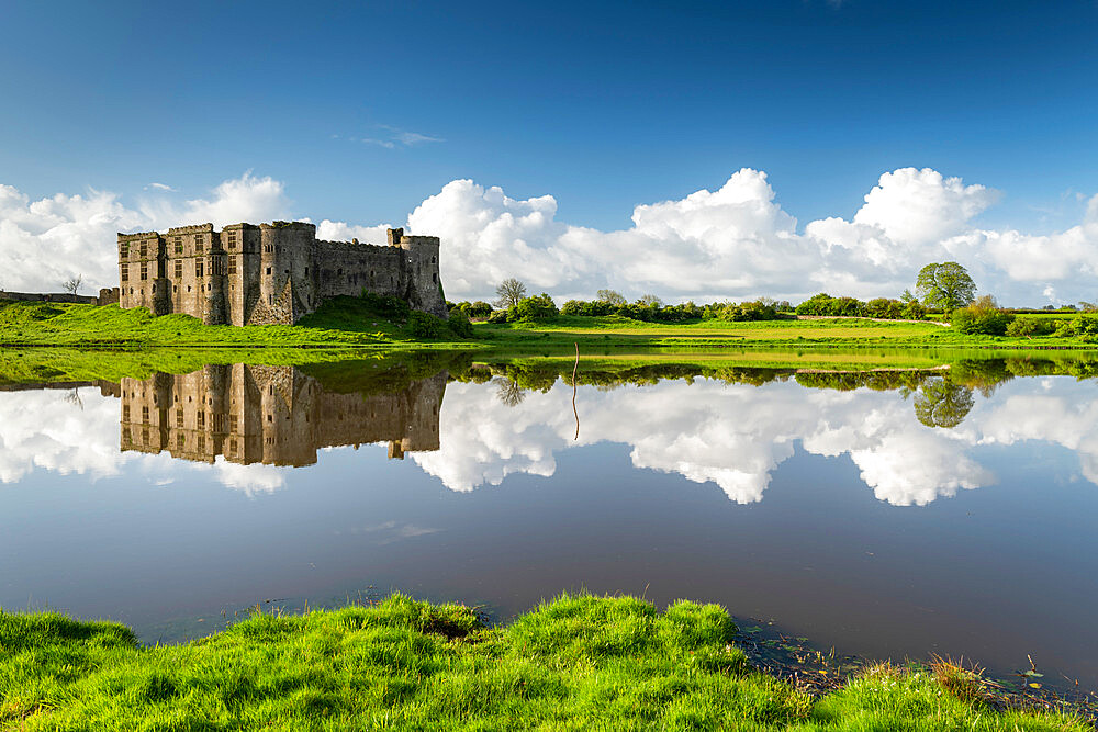 The magnificent ruins of Carew Castle reflected in the Mill Pond in spring, Carew, Pembrokeshire, Wales, United Kingdom, Europe