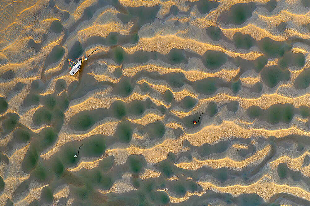 Boat stranded on the Town Bar sandbar in the Camel Estuary at low tide, Rock, Cornwall, England, United Kingdom, Europe