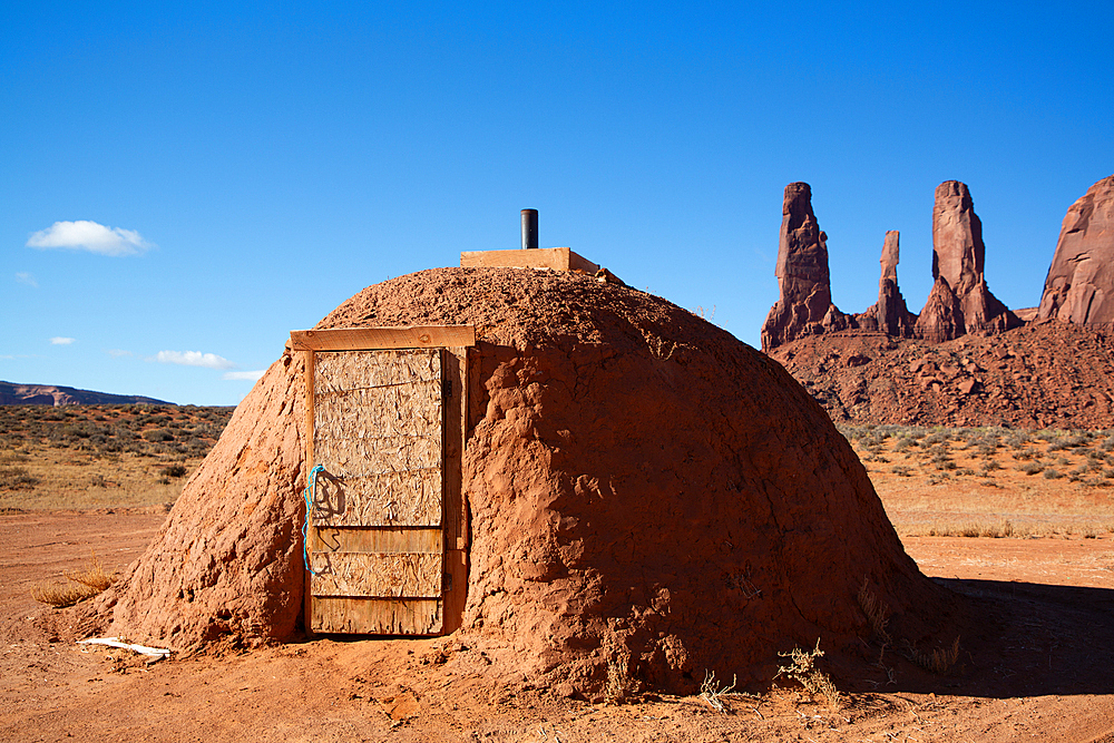 Navajo Hogan House, Three Sisters (background), Monument Valley Navajo Tribal Park, Utah, USA