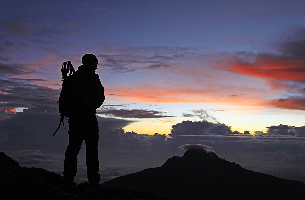 A climber looks towards Mawenzi from near the summit of Mount Kilimanjaro at dawn, Tanzania, East Africa, Africa