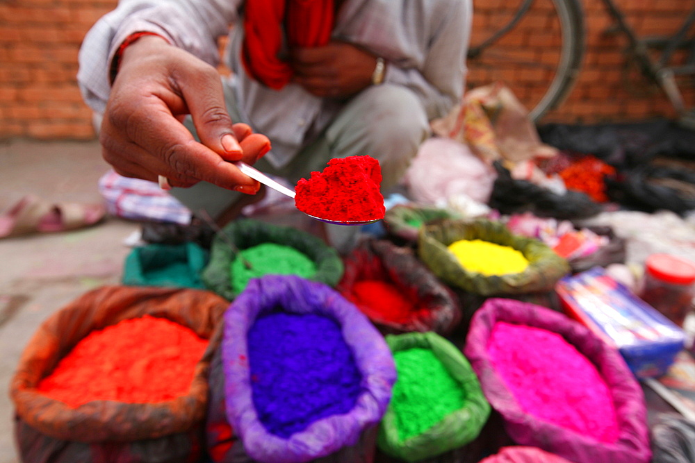 A dye trader offers his brightly coloured wares in a roadside stall in Kathmandu, Nepal, Asia