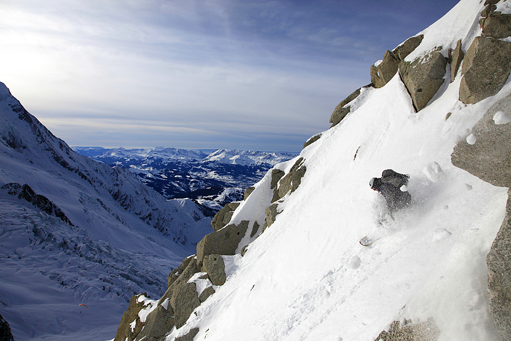 A snowboarder tackles a challenging off piste descent on Mont Blanc, Chamonix, Haute Savoie, French Alps, France, Europe