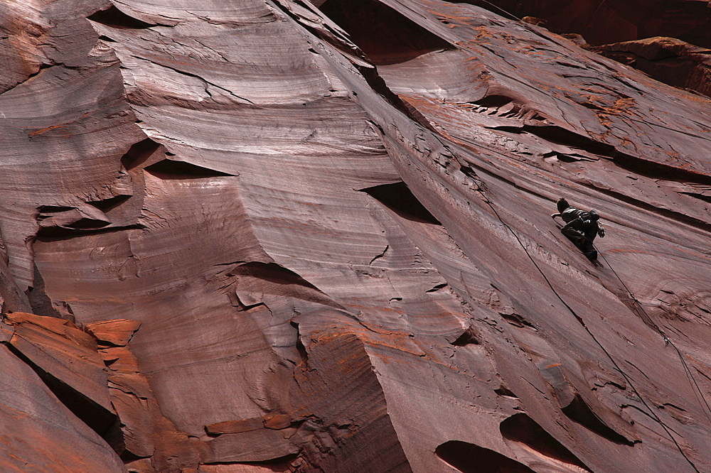 A climber scales cliffs at Indian Creek in the Utah Desert, Canyonlands National Park, Utah, United States of America, North America