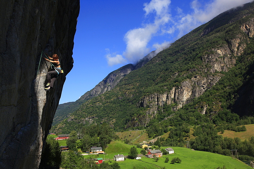 A female climber tackles a steep cliff at Loven, near Aurland, western Norway, Scandinavia, Europe