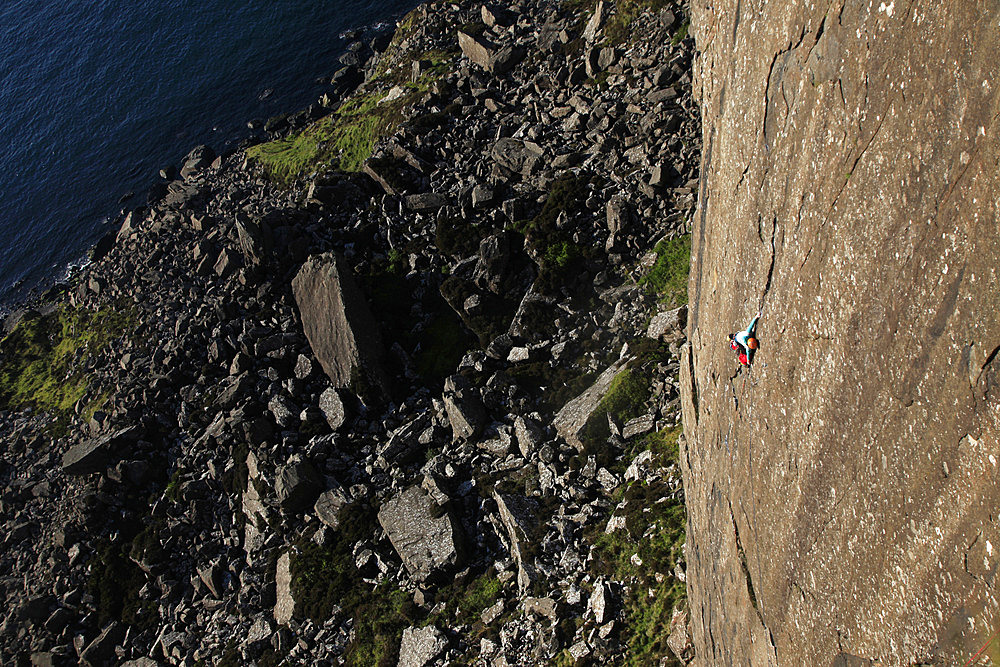 A climber scales the 100 metre cliffs at Fair Head, County Antrim, Ulster, Northern Ireland, United Kingdom, Europe