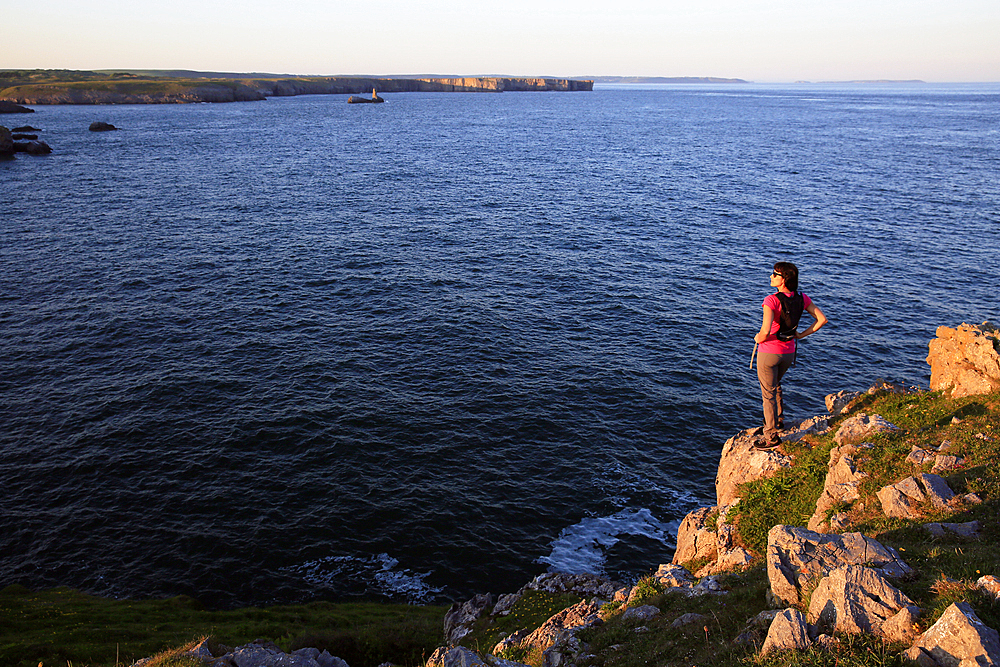 A woman hiking at St. Govan's Head on the Pembrokeshire Coast, Wales, United Kingdom, Europe