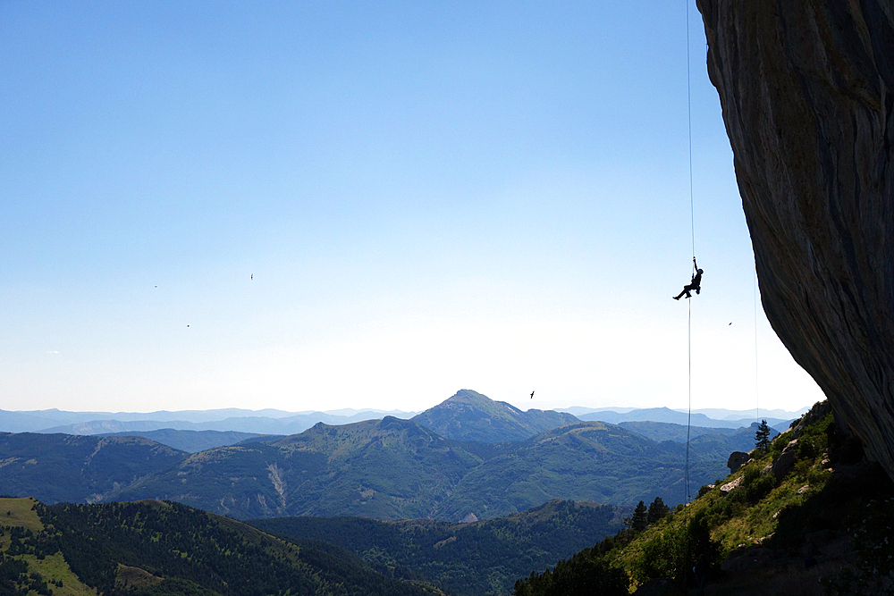 A climber ascends a rope on the cliffs of Ceuse, a mountain in the Alpes Maritimes, Haute Alpes, France, Europe