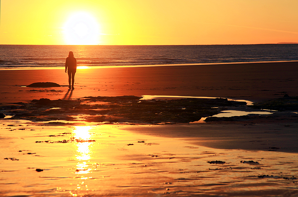 A woman walks on Southerndown beach, Ogmore, South Wales, United Kingdom, Europe