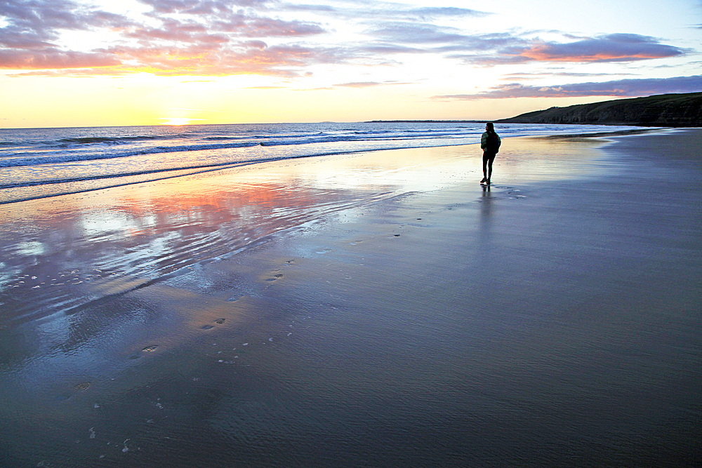 A woman walks on Southerndown beach, Ogmore, South Wales, United Kingdom, Europe