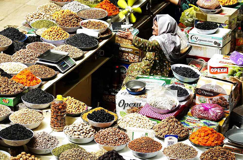 Woman selling nuts and dried fruit on a stall in the Central Market, Dushanbe, Tajikistan, Central Asia, Asia