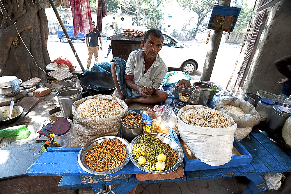 Chaat stall, man mixing sprouting seeds and lentils and puffed rice with spices, Dalhousie Square, Kolkata (Calcutta), West Bengal, India, Asia