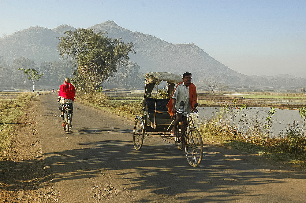 Early morning rickshaw wallahs pass each other in rural countryside near Baliguda, Orissa, India