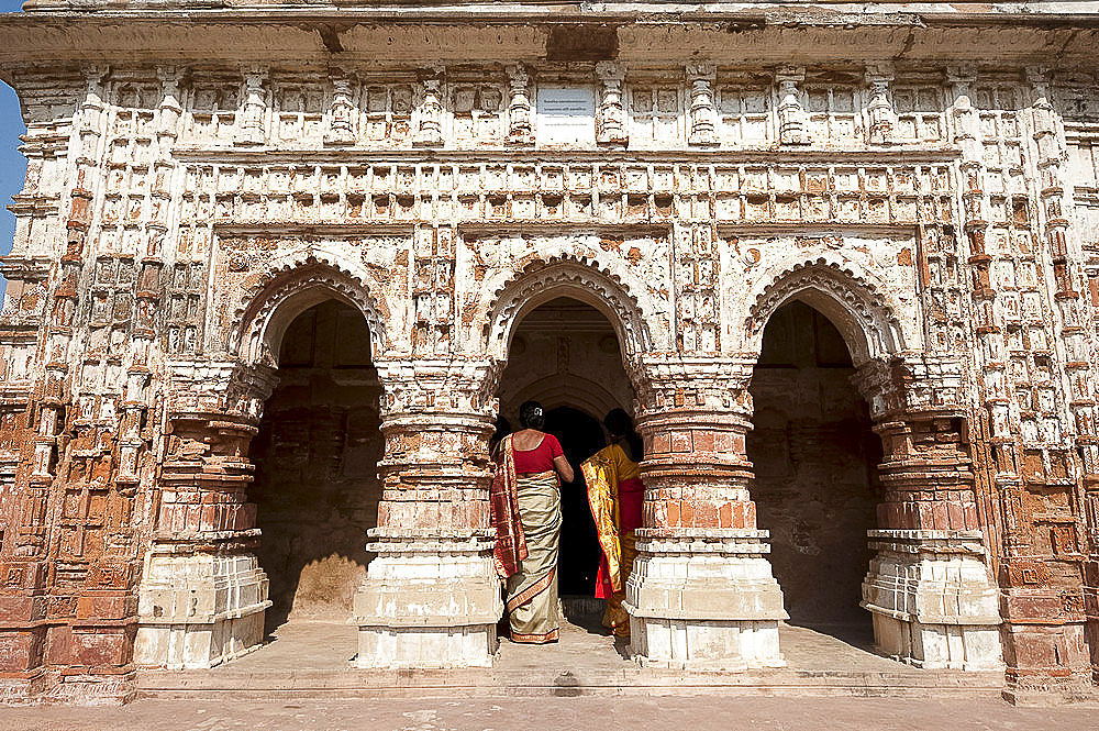 Two women in saris visiting the Lalji terracotta Hindu temple, built in 1739 and dedicated to Radha Krishna, Kalna,West Bengal, India, Asia