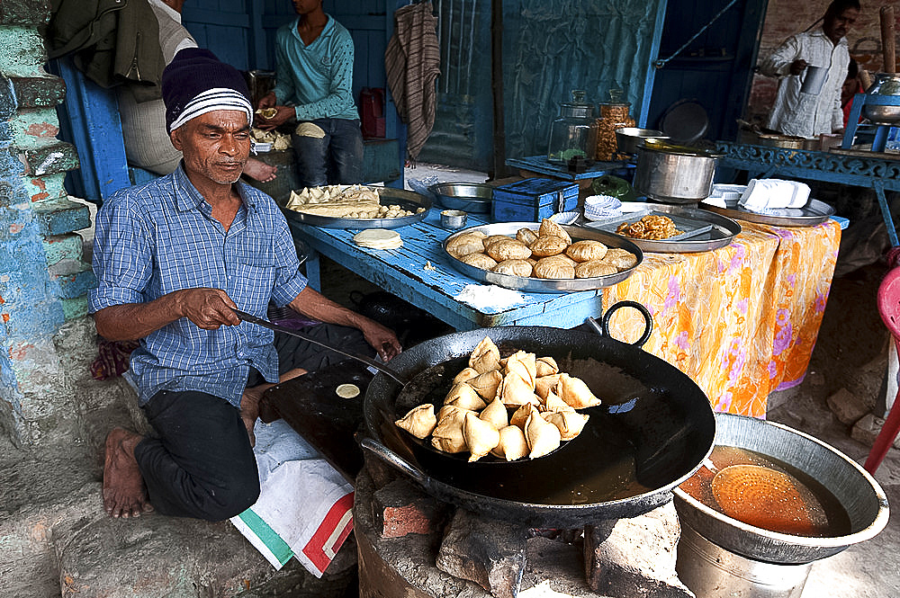 Samosas, pani puri and other lunchtime snacks being made by stallholder outside Ramnagar Fort, Varanasi, Uttar Pradesh, India, Asia