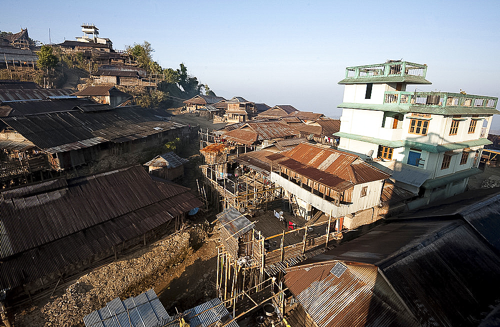 Naga village houses with bamboo stilted verandahs, clinging to the hillside, in morning light, Chanlangshu village, Nagaland, India, Asia