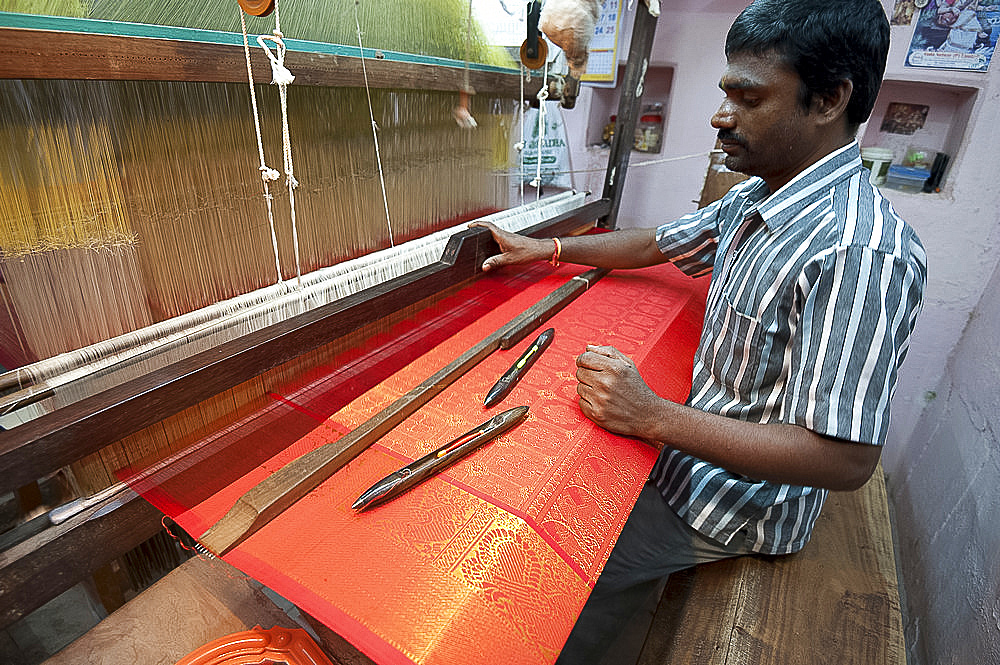 Silk weaver at his loom in his house, weaving sought after red and gold Kanchipuram silk sari, Kanchipuram, Tamil Nadu, India, Asia