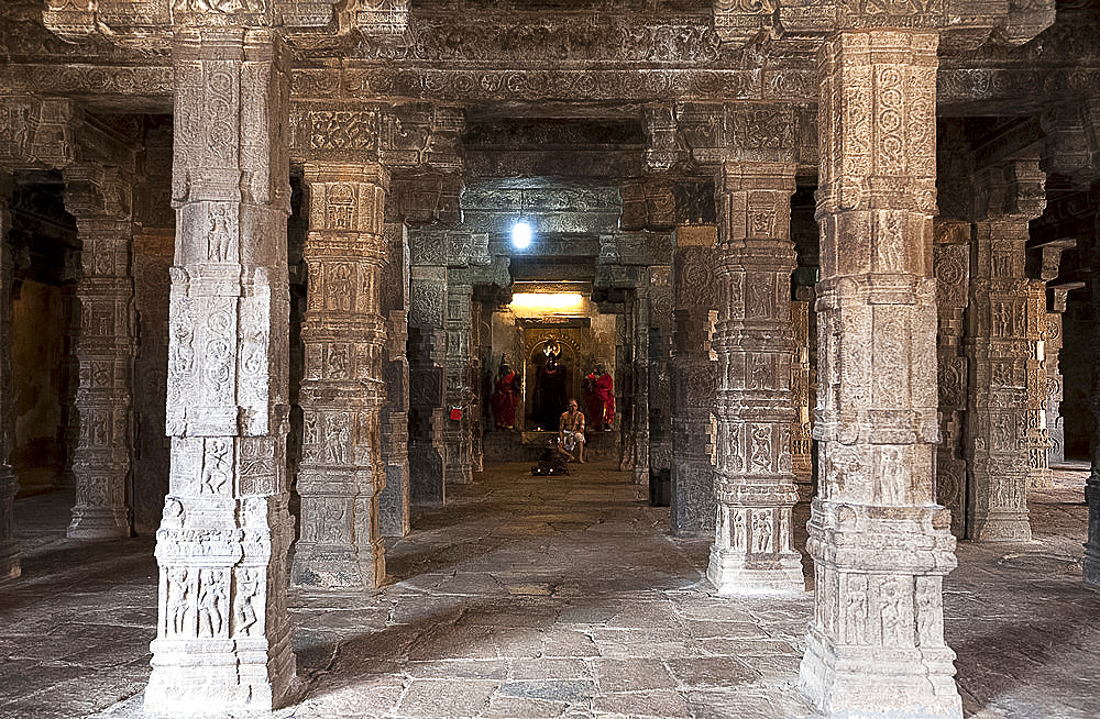 Hindu priest sitting at shrine in the stone in the pillared hall in Swaminathaswamy Murugan temple, Swamimalai, Tamil Nadu, India, Asia