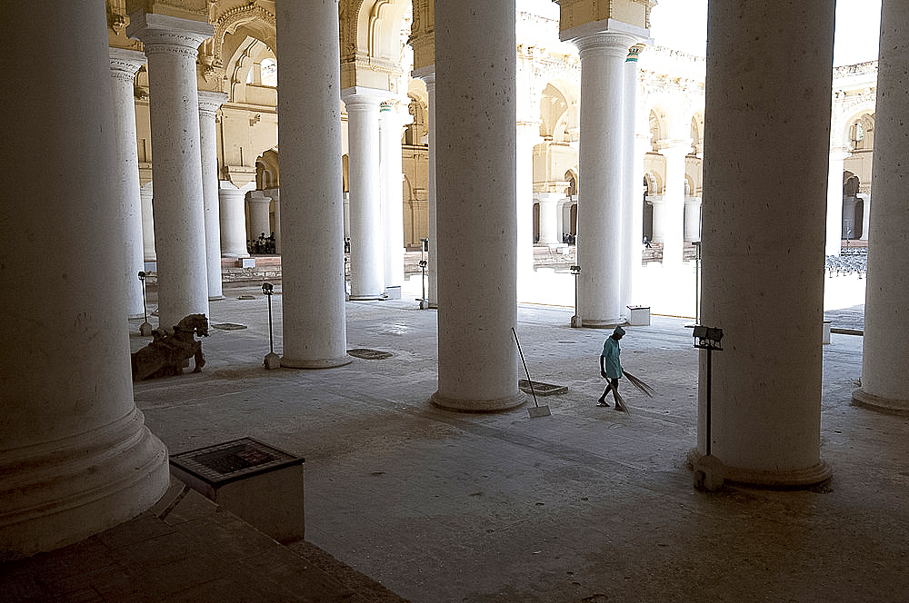 Cleaner with palm brush sweeping thousand pillar hall inside the 17th century Thirumalai Nayakkar Mahal, Madurai, Tamil Nadu, India, Asia