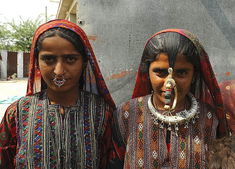 Two young Jat women, one wearing traditional brass Jat tribal nose ring, jewellery and clothing, Bhidara village, Kutch, Gujarat, India, Asia