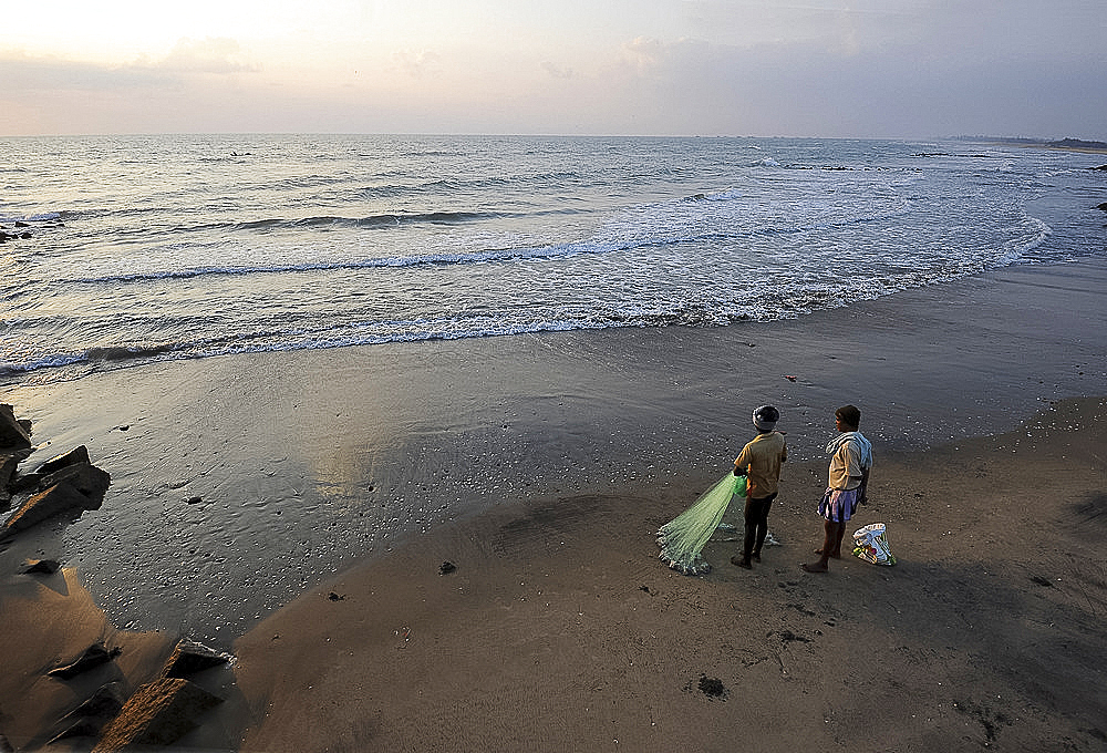 Fishermen preparing to cast fishing net at sunrise into the waters of the Bay of Bengal, Tranquebar, Tamil Nadu, India, Asia