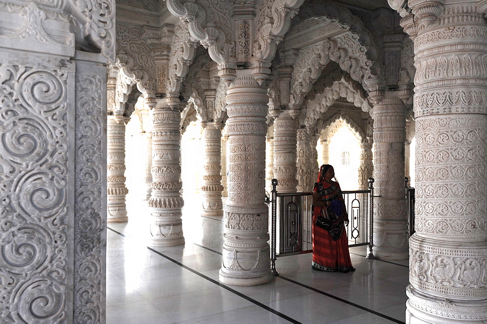 Hindu woman in red sari inside the ornate white marble Swaminarayan Temple, built following the 2001 earthquake, Bhuj, Gujarat, India, Asia