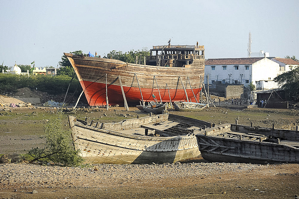 Almost completed ocean going dhow under construction at low tide, handmade from Sal wood on the Rukmavati River, Mandvi, Gujarat, India, Asia